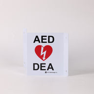 A tent-shaped 3D metal wall sign that marks an AED is present to individuals approaching from any direction