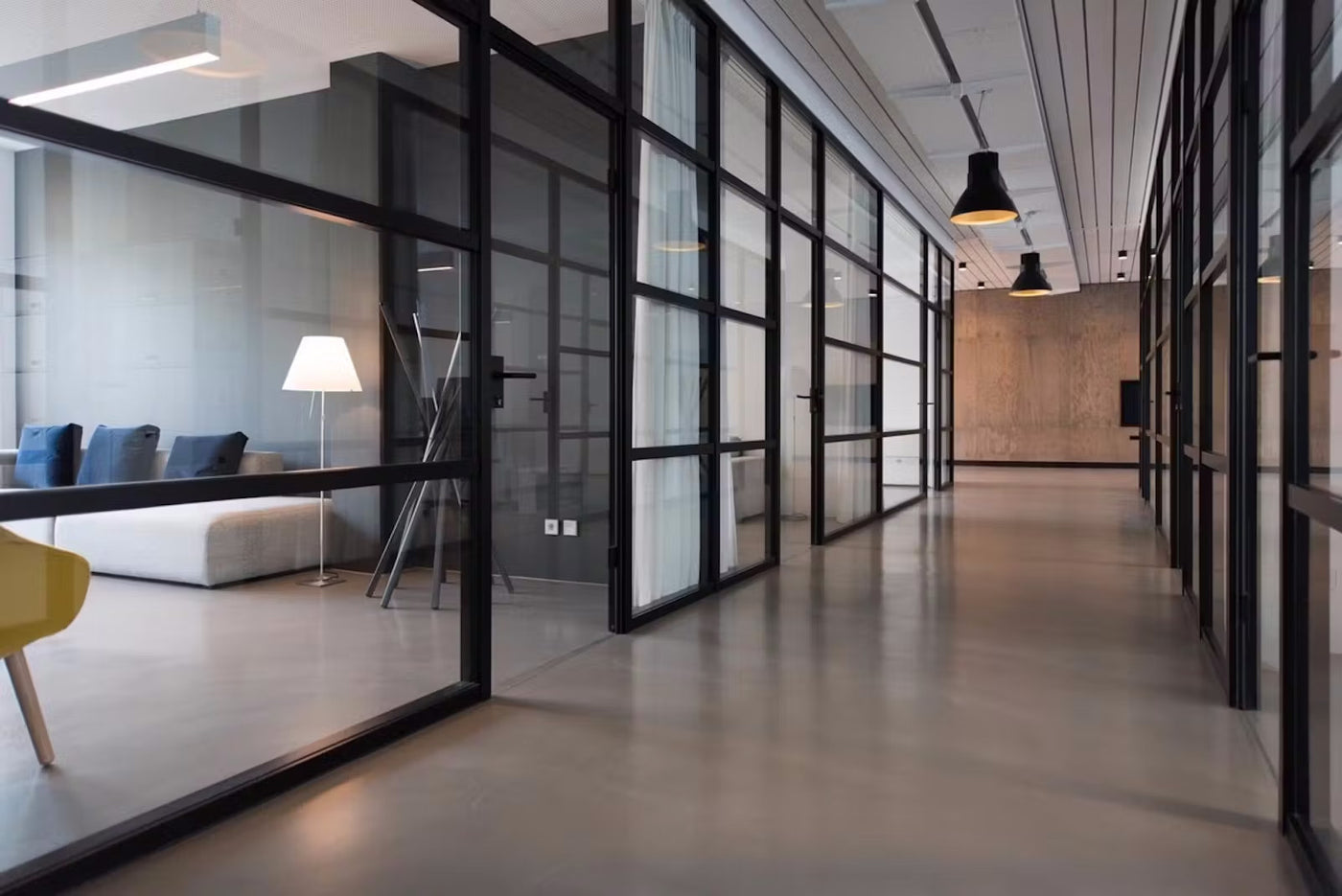 An office building hallway with glass walls