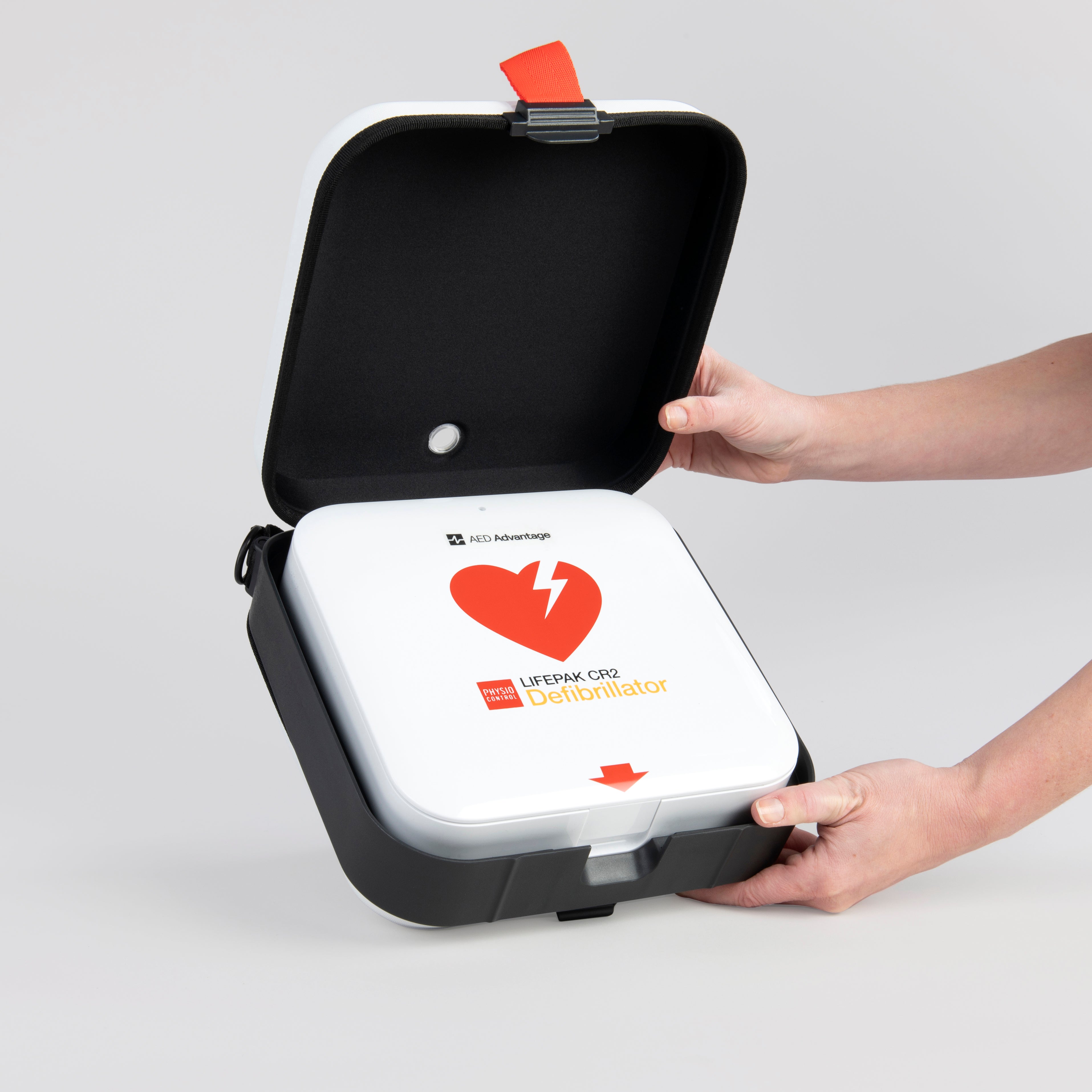 A white and red AED's carry case being opened by hand