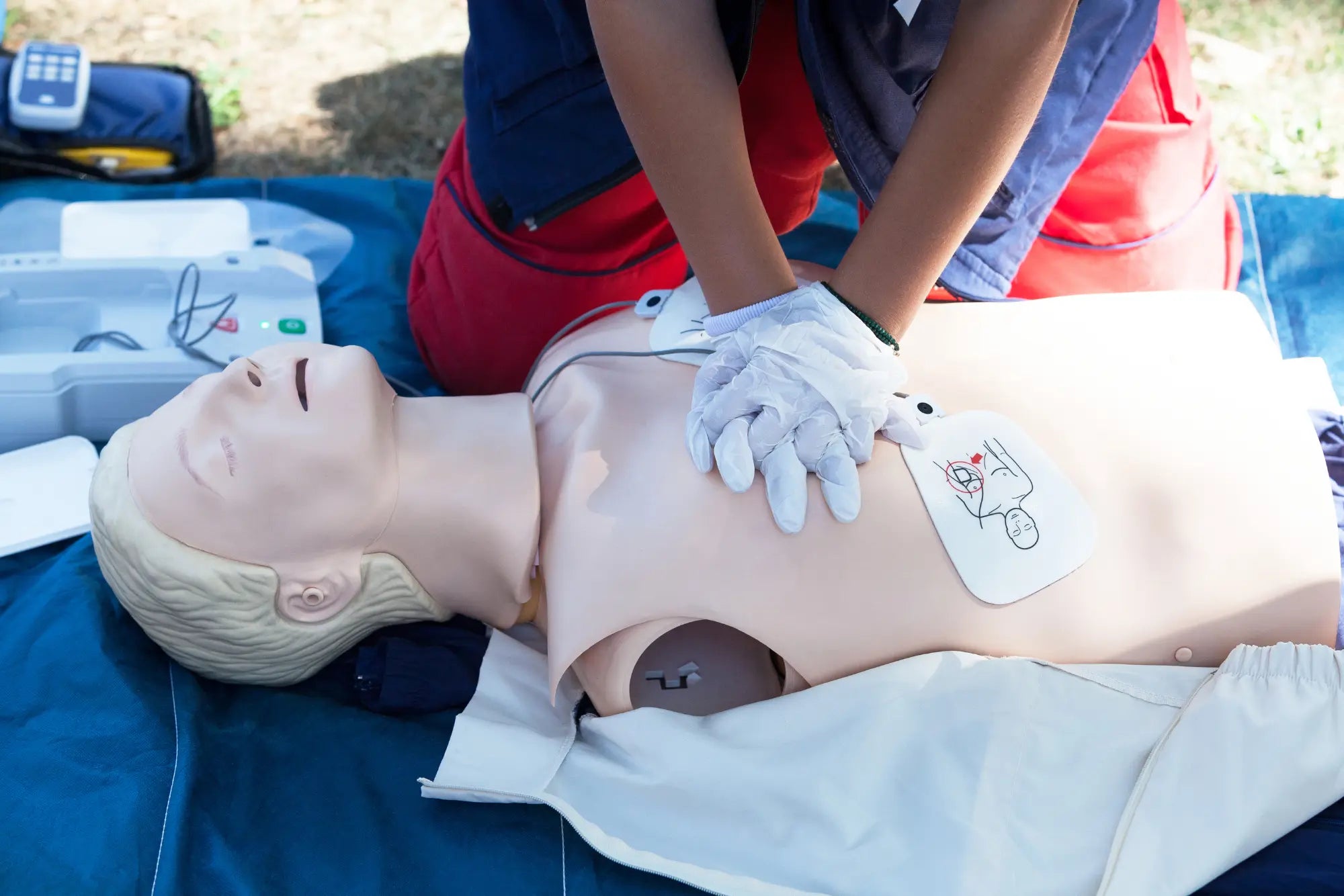 A first resonder is performing CPR on a CPR dummy