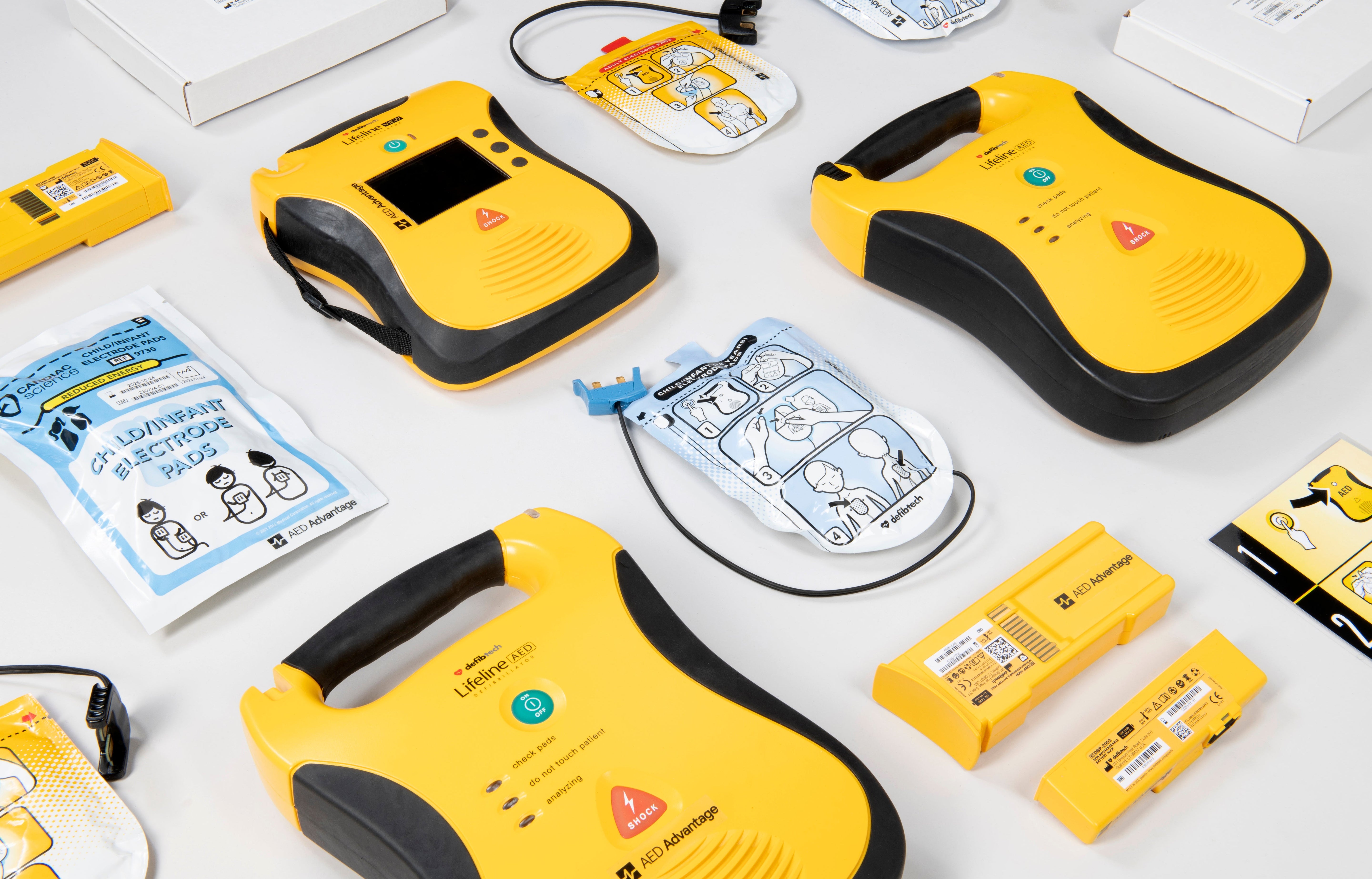 A collage of bright yellow Lifeline AEDs and their accessories
