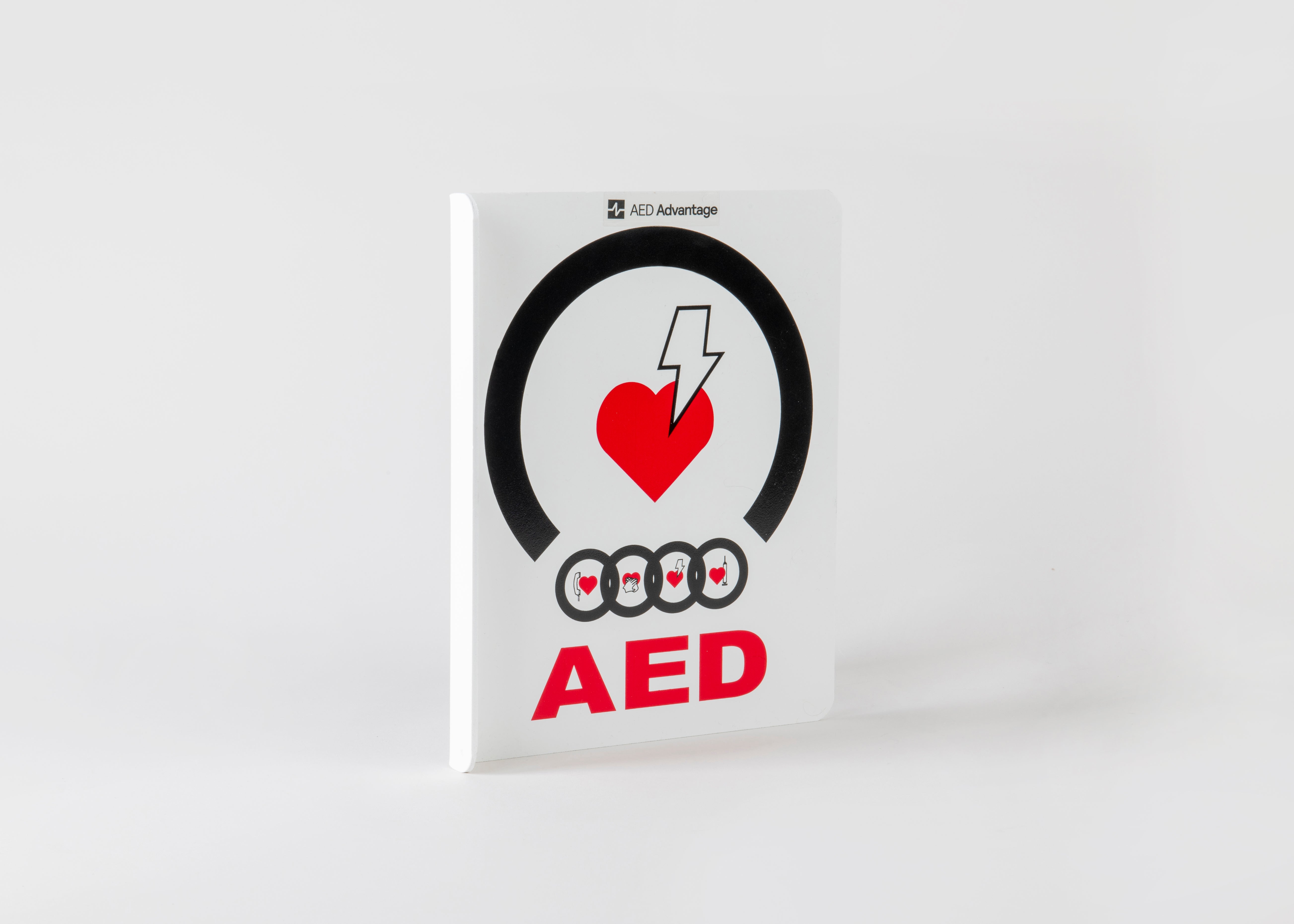 A white plastic rectangular wall sign containing large bold text indicating an AED is present 