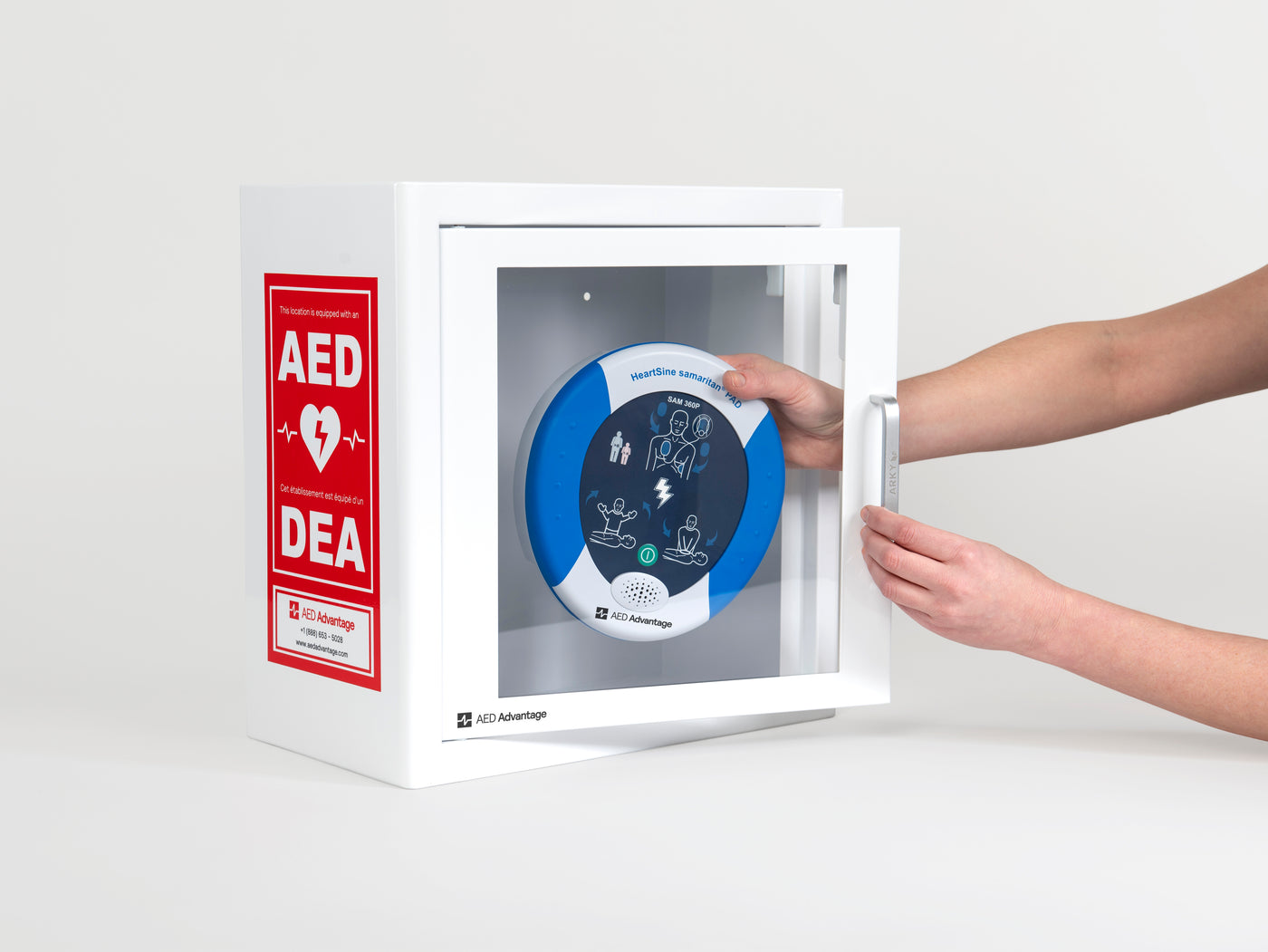 A blue and white HeartSine 360P AED being retrieved by hand from a white metal cabinet with red decals
