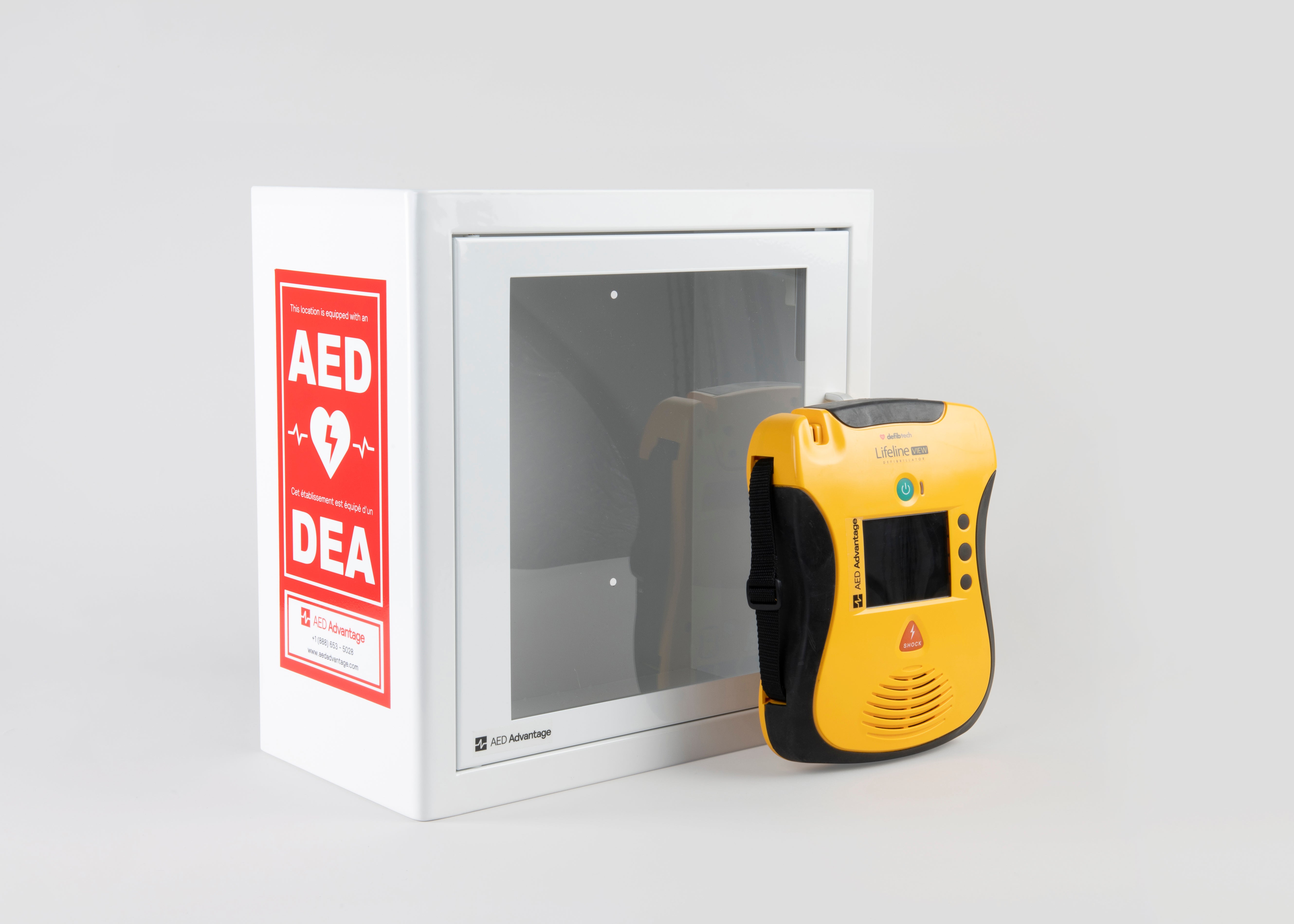 A yellow and black Defibtech Lifeline VIEW AED standing in front of a white metal cabinet with red decals