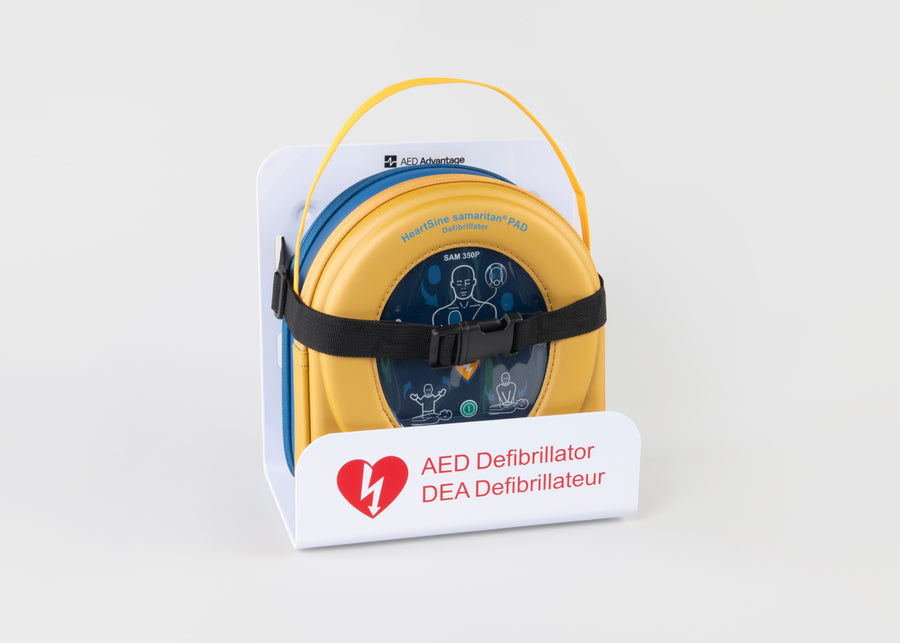 A HeartSine 350P AED in its yellow carry case strapped into a white wall mount bracket