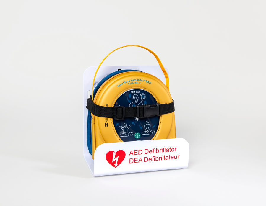 A HeartSine 360P AED in its yellow carry case strapped into a white wall mount bracket