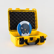 A blue and gray HeartSine 500P AED inside a bright yellow hardshell carry case