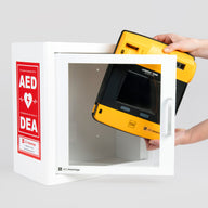 A black and yellow LIFEPAK 1000 AED being retrieved by hand from a white metal cabinet with red decals