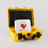 A white and red LIFEPAK CR2 AED machine inside a bright yellow hardshell carry case