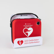 A Philips OnSite AED in a bright red carry case displayed in a white metal wall mount bracket