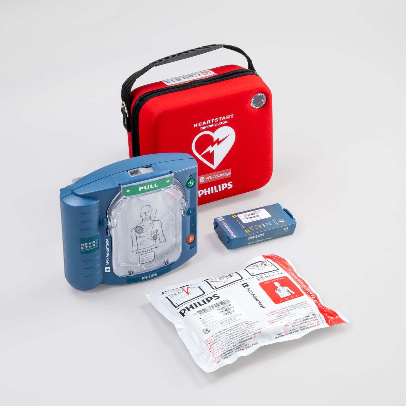 A Philips OnSite AED displayed with its bright red carry case, electrode pads, and battery.