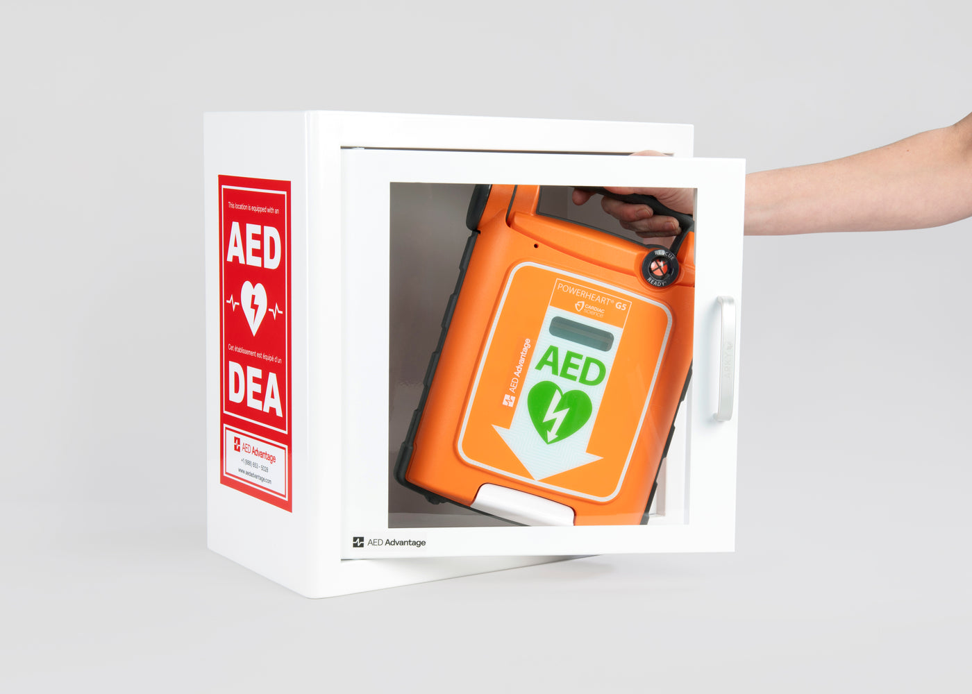 An orange Powerheart G5 AED being retrieved by hand from a white metal cabinet with red decals