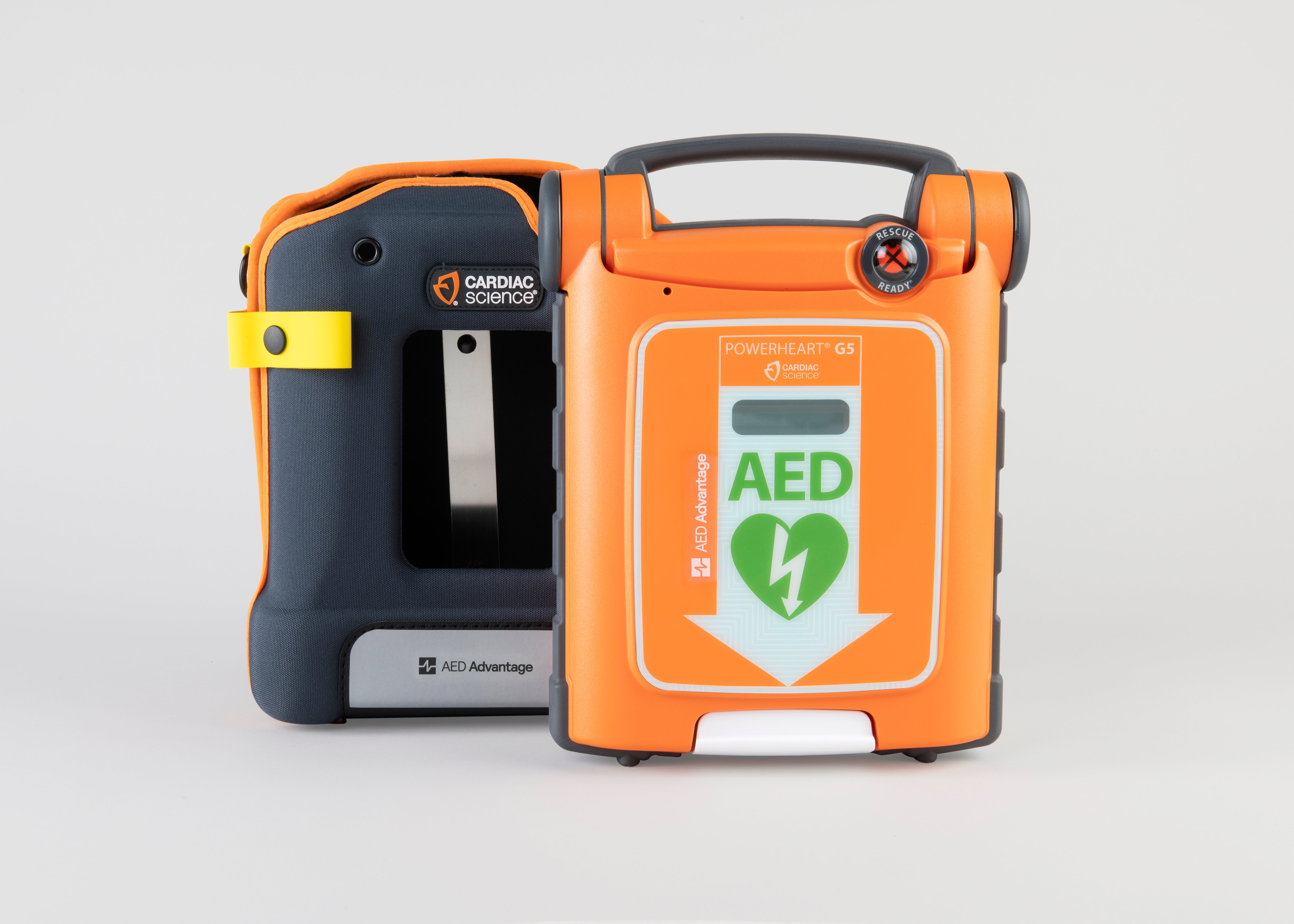 An orange Powerheart G5 AED standing next to its gray carry case