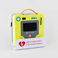 A green ZOLL AED 3 machine displayed in a white metal wall mount bracket