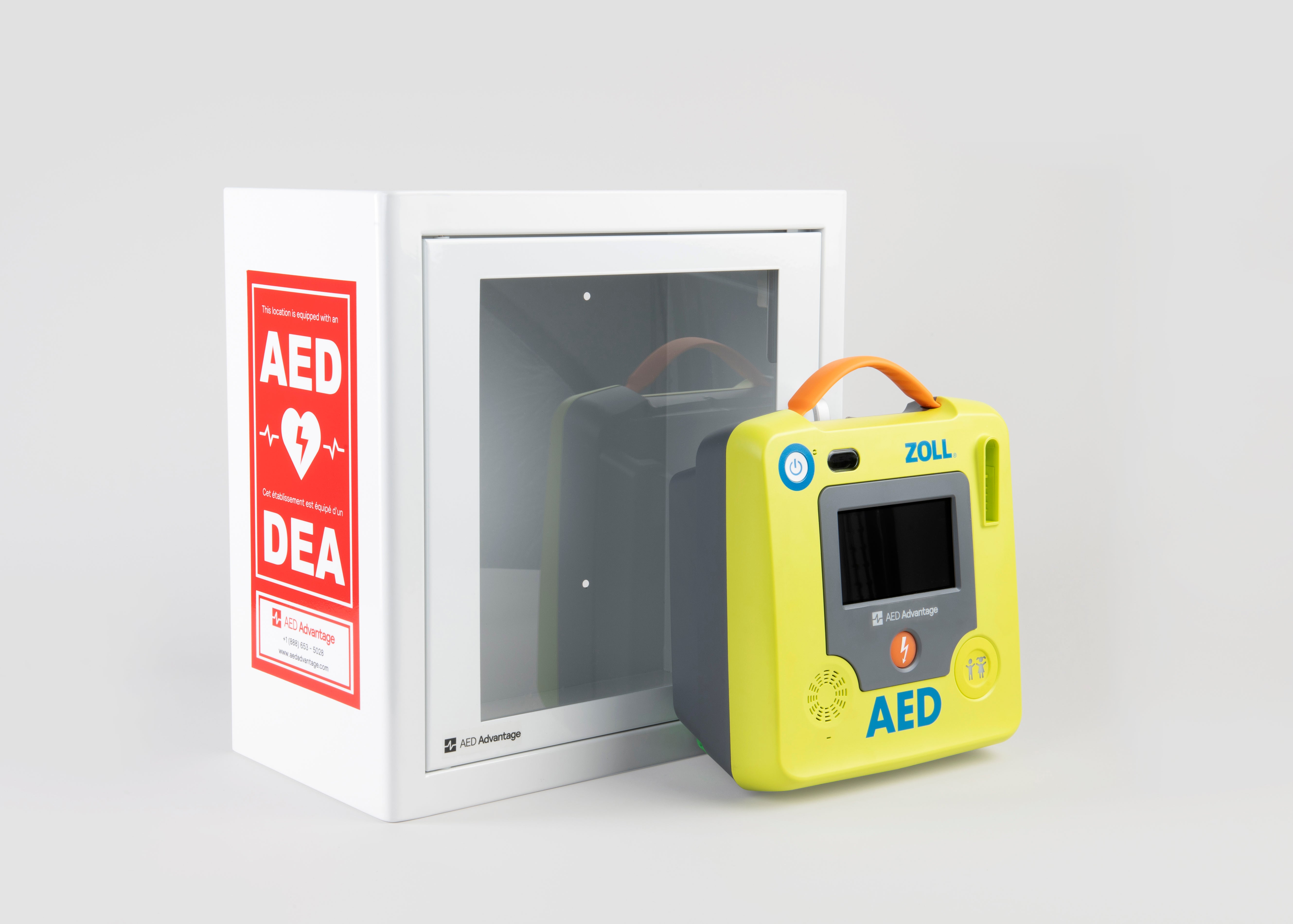 A green ZOLL AED 3 machine standing in front of a white metal cabinet with red decals